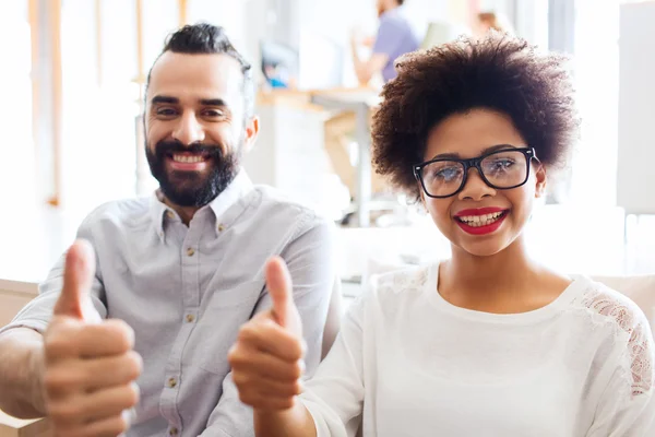 Feliz equipo creativo en la oficina mostrando pulgares hacia arriba — Foto de Stock