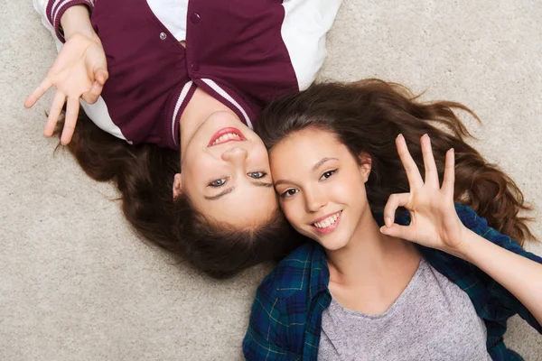 Feliz sonriente bastante adolescentes tumbado en el suelo —  Fotos de Stock