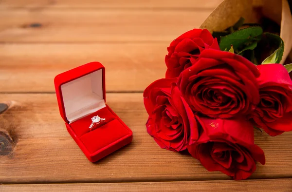 Close up van diamond engagement ring en rode rozen — Stockfoto