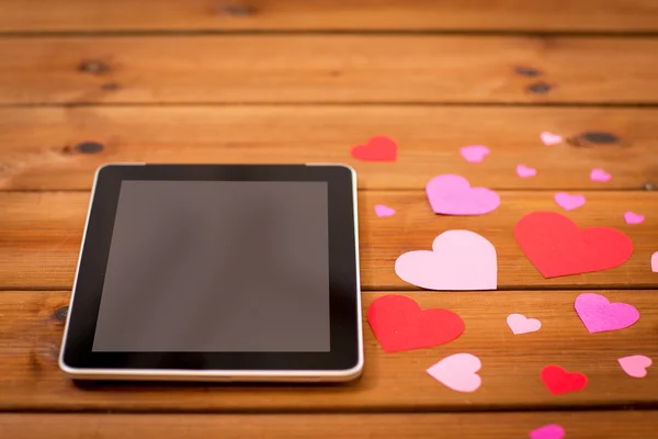 Close up of tablet pc and hearts on wood — Stock Photo, Image