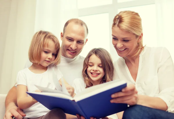 Familia sonriente y dos niñas con libro —  Fotos de Stock