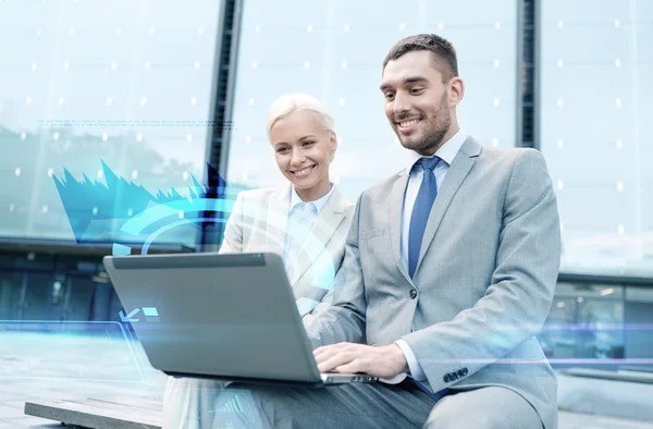 Smiling businesspeople with laptop outdoors — Stock Photo, Image