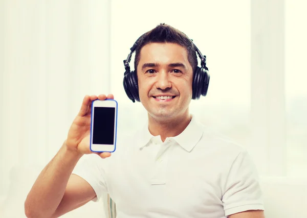 Счастливый человек со смартфоном и наушниками — стоковое фото