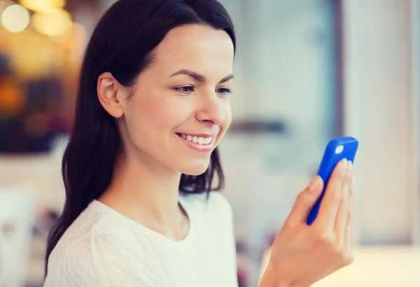 Close-up van lachende vrouw met smartphone in café — Stockfoto