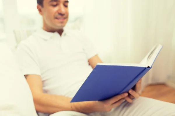 Close up de homem feliz lendo livro em casa — Fotografia de Stock