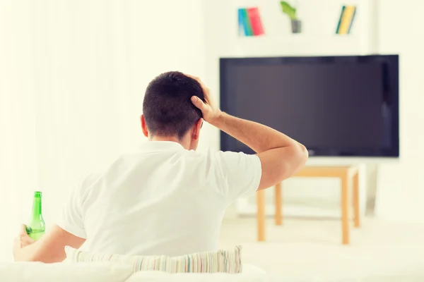 Hombre viendo la televisión y bebiendo cerveza en casa —  Fotos de Stock