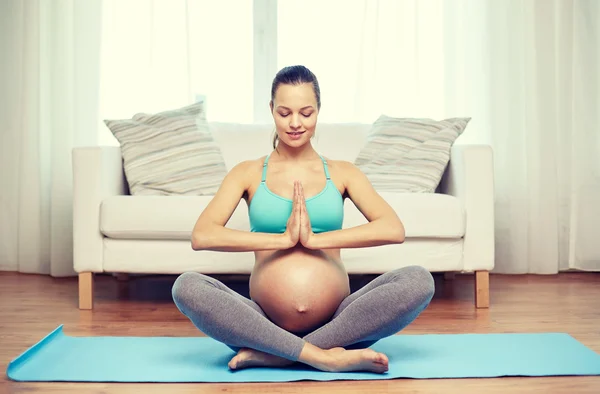 Šťastná těhotná žena medituje doma — Stock fotografie