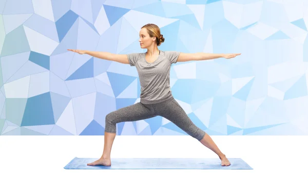 Kvinnan gör krigare yogaställning på matta — Stockfoto