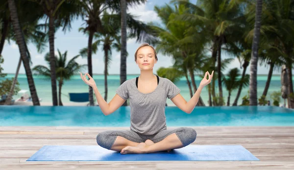 Mulher fazendo meditação de ioga em lótus posar no tapete — Fotografia de Stock