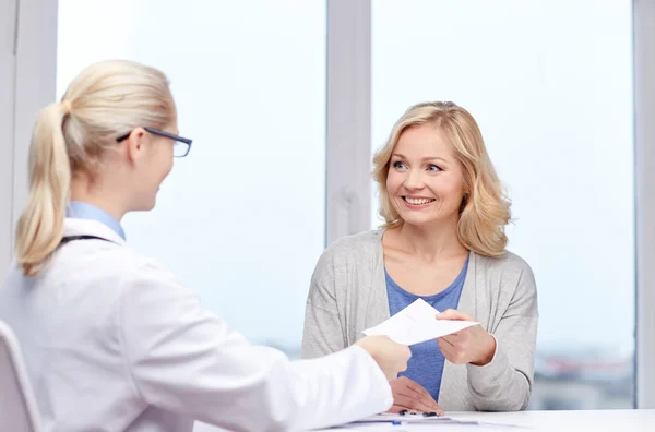 Médico que da prescripción a la mujer en el hospital — Foto de Stock