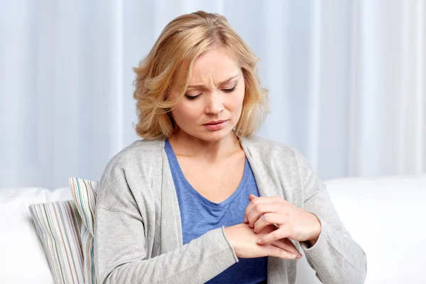 Unhappy woman suffering from hand inch at home — Stock Photo, Image