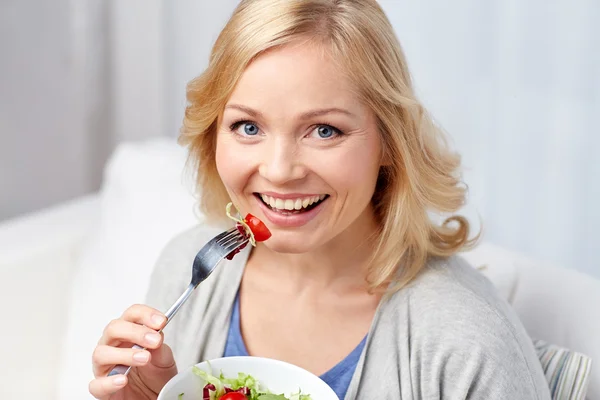 Sorridente donna di mezza età mangiare insalata a casa — Foto Stock