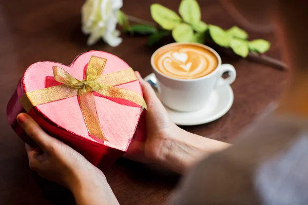 Primer plano de las manos sosteniendo caja de regalo en forma de corazón —  Fotos de Stock