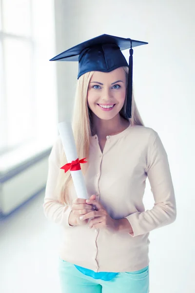 Student in afstuderen cap met certificaat — Stockfoto