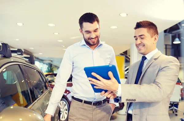 Happy man with car dealer in auto show or salon — Stock Photo, Image