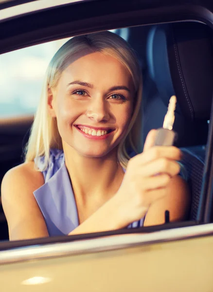 Mujer feliz consiguiendo la llave del coche en demostración auto o salón —  Fotos de Stock