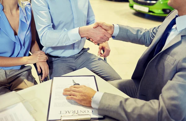 Handshake of customer and car dealer in auto salon — Stock Photo, Image