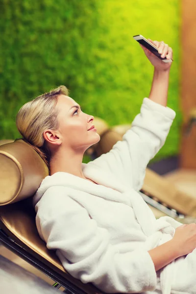 Beautiful young woman with smartphone at spa — Stock Photo, Image