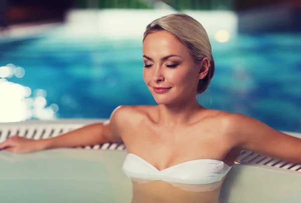 Happy womani sentado em jacuzzi à beira da piscina — Fotografia de Stock