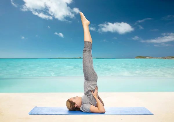 Mujer haciendo yoga en hombrostand pose en la estera —  Fotos de Stock