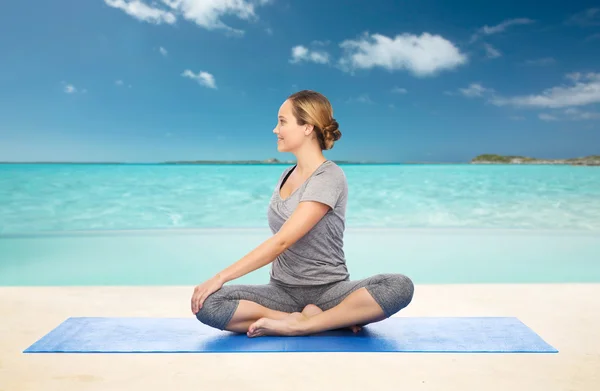 Vrouw maken yoga in twist pose op de mat — Stockfoto