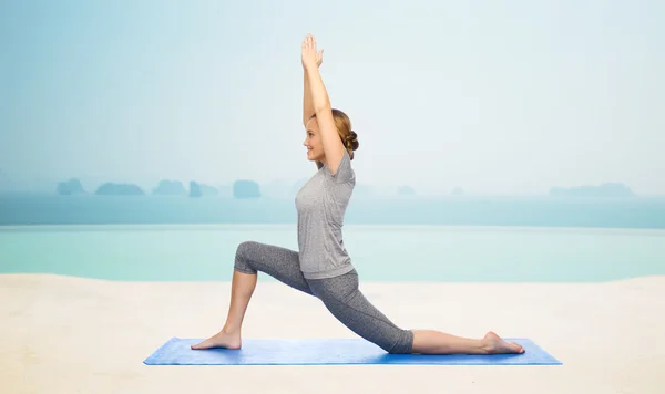 Glückliche Frau macht Yoga in niedrigem Ausfallschritt auf Matte — Stockfoto