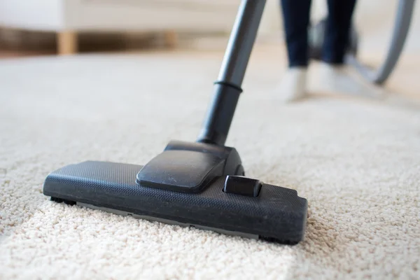 Close up of woman legs with vacuum cleaner at home — Stock Photo, Image