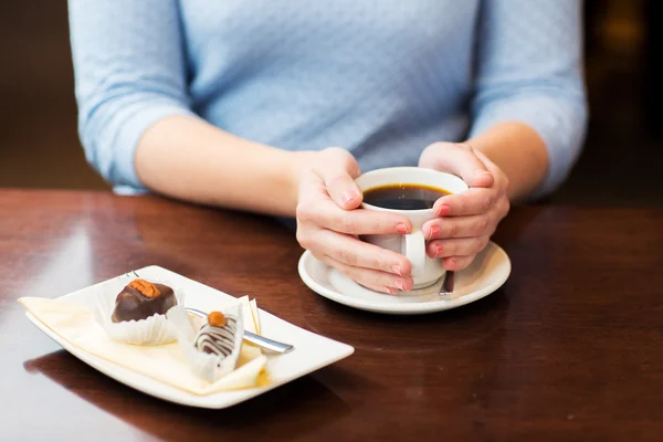 Primo piano di donna che tiene tazza di caffè e dessert — Foto Stock