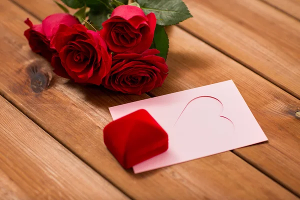 Nahaufnahme von Geschenkbox, roten Rosen und Grußkarte — Stockfoto