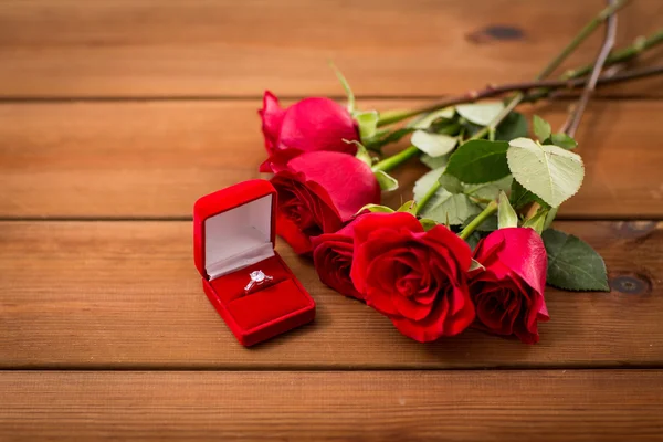 Nahaufnahme von Diamant-Verlobungsring und roten Rosen — Stockfoto