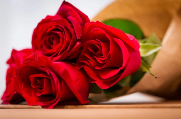 Close up of red roses bunch wrapped into paper — Stock Photo, Image