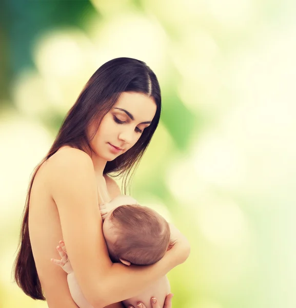 Mãe feliz alimentando seu bebê adorável — Fotografia de Stock