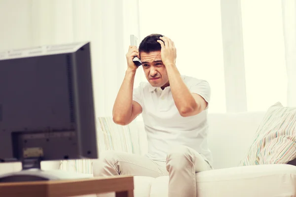 Enttäuschter Mann schaut zu Hause fern — Stockfoto