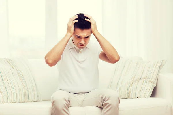 Unhappy man suffering from head ache at home — Stock Photo, Image