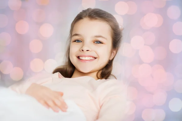 Happy smiling girl lying awake in bed at home — Stock Photo, Image