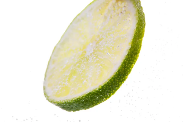 Lime szeletet leessen, vagy vízbe — Stock Fotó