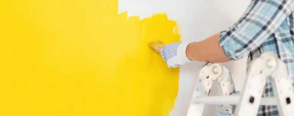 Close up of male in gloves painting a wall — Stock Photo, Image