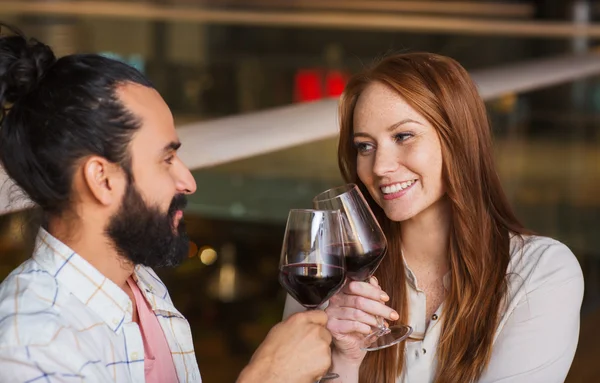 Pareja bebiendo vino tinto y tintineo vasos — Foto de Stock