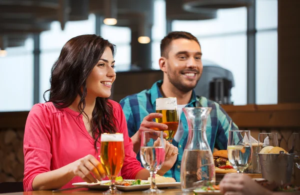 Přátelé stolování a pití piva v restauraci — Stock fotografie