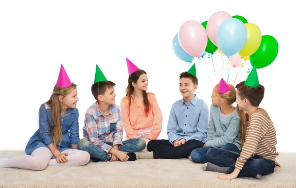 Feliz sonriente niños en partido sombreros en cumpleaños —  Fotos de Stock