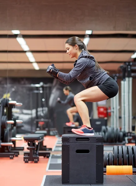 Donna che fa squat su pnatfom in palestra — Foto Stock