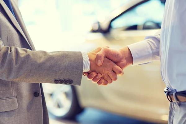 Close up of male handshake in auto show or salon — Stock Photo, Image