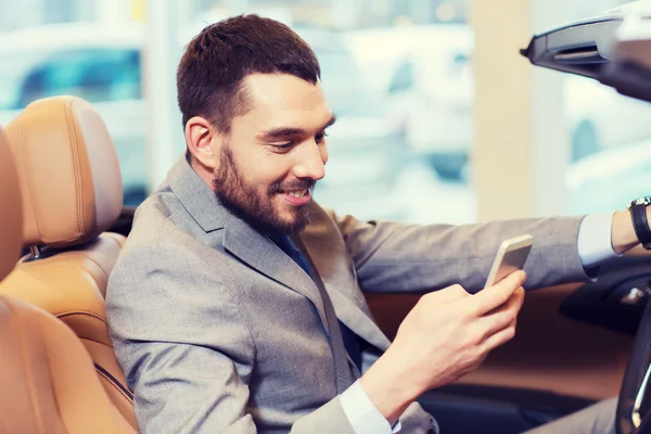 Homme heureux assis en voiture au salon de l'auto ou salon — Photo