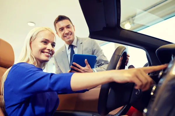 Mulher feliz com negociante de carro em auto show ou salão de beleza — Fotografia de Stock