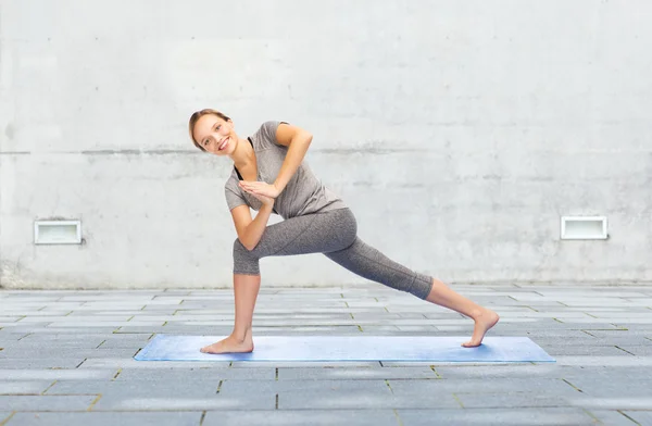 Женщина делает yoga low angle выпад поза на циновке — стоковое фото