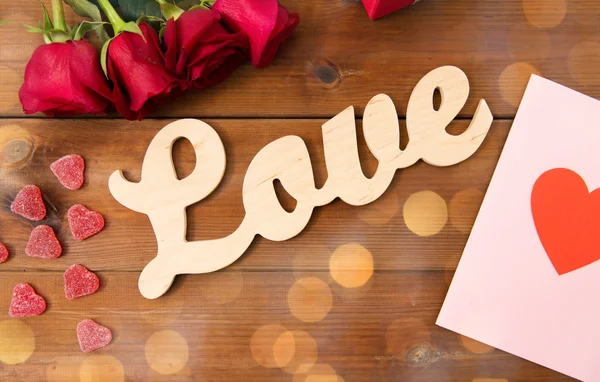 Close up of gift box, red roses and greeting card — Stock Photo, Image