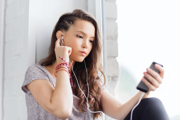 Chica adolescente con teléfono inteligente y auriculares — Foto de Stock