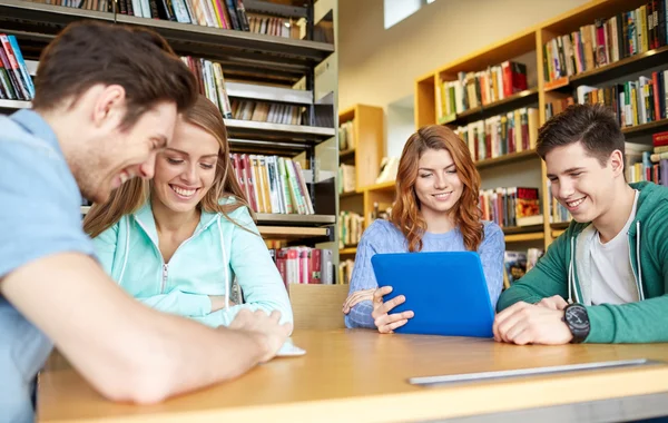 Alunos felizes com tablet pc na biblioteca — Fotografia de Stock