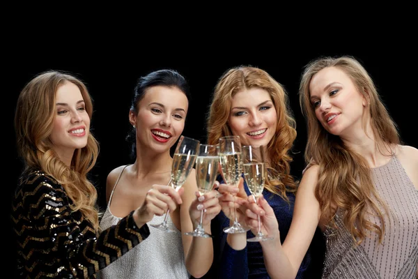 Gelukkig vrouwen champagneglazen rammelende over zwart — Stockfoto