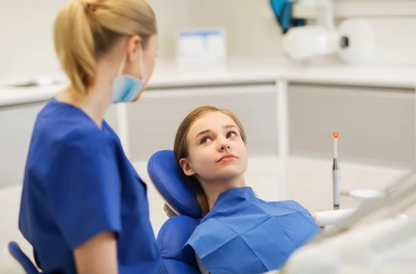 Dentista mujer feliz con chica paciente en la clínica —  Fotos de Stock